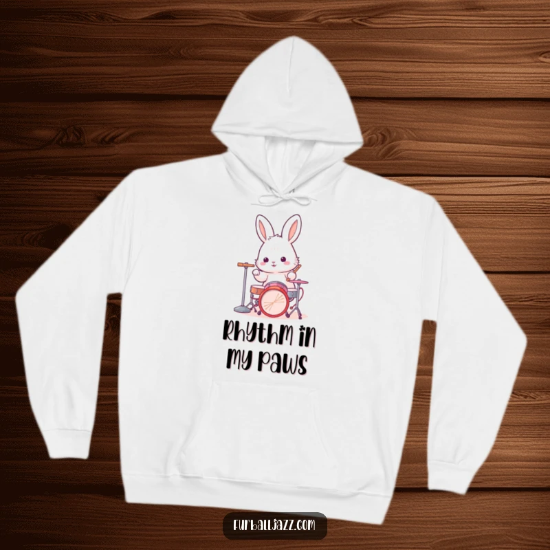 Funny rabbit hoodie with a fluffy bunny character intensely playing a miniature drum kit, exuding a cool drummer attitude.
